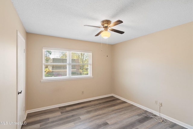spare room featuring baseboards, a textured ceiling, wood finished floors, and a ceiling fan