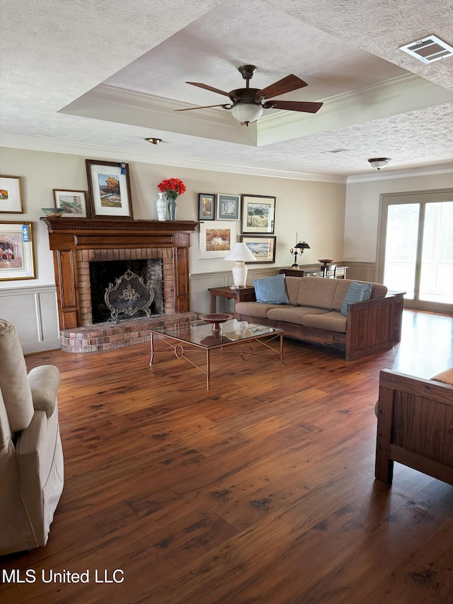 living room featuring crown molding, a raised ceiling, and a textured ceiling