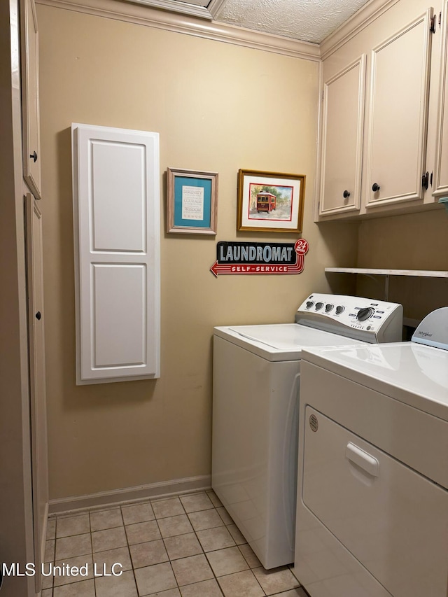 laundry area featuring separate washer and dryer, cabinet space, baseboards, and light tile patterned flooring