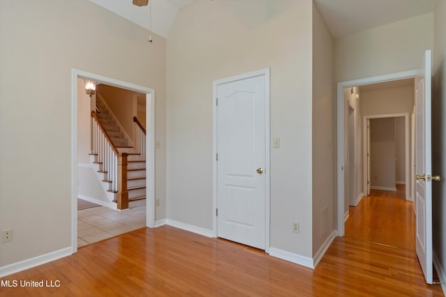 6375 Darren Dr, Olive Branch, MS 38654 - empty room featuring light wood finished floors, stairway, high vaulted ceiling, and baseboards