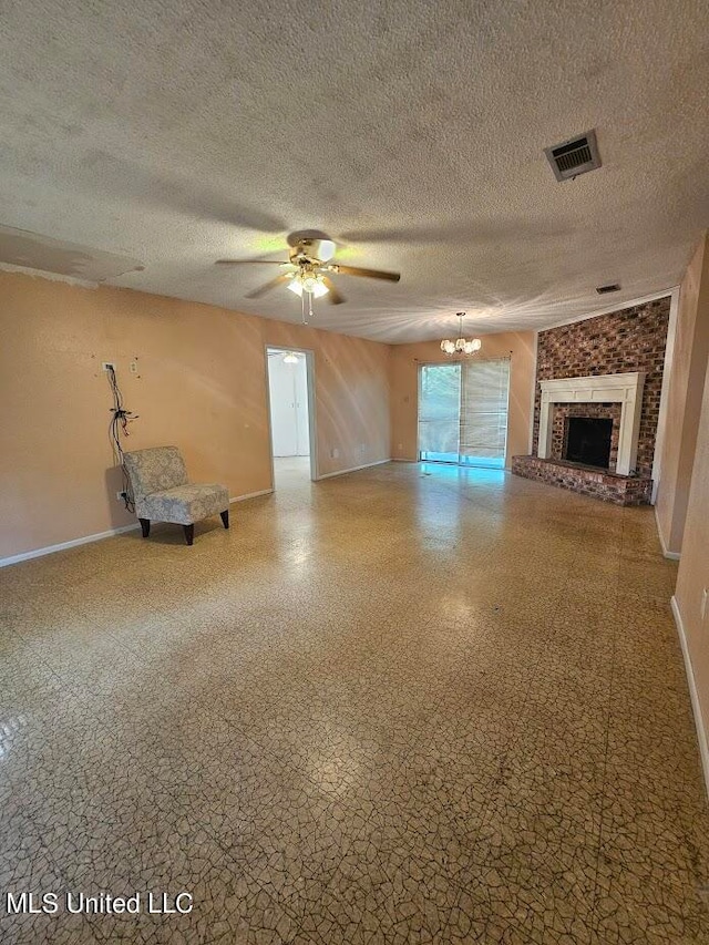 unfurnished living room with a brick fireplace, a textured ceiling, and ceiling fan with notable chandelier