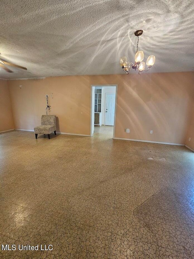 empty room with a textured ceiling and ceiling fan with notable chandelier