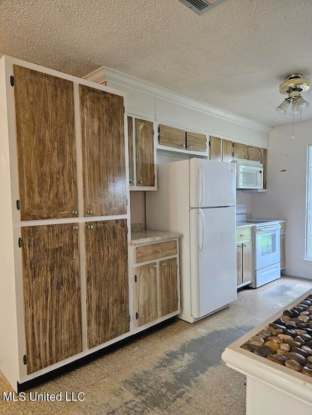 kitchen featuring a textured ceiling, ceiling fan, and white appliances