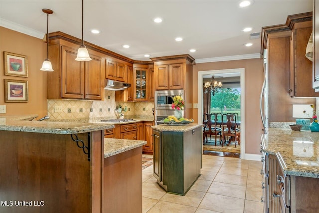 kitchen featuring brown cabinetry, a peninsula, backsplash, and light stone countertops