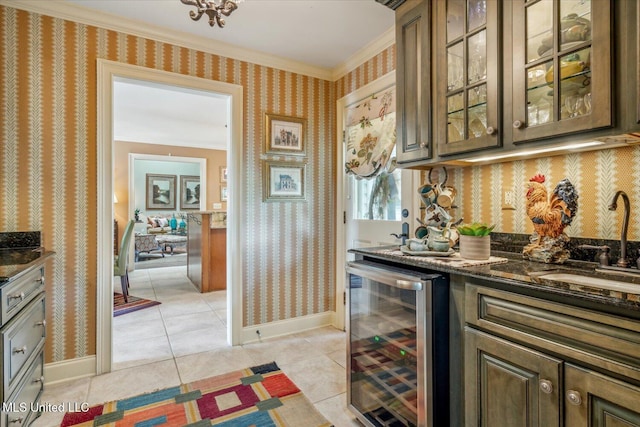 bar featuring ornamental molding, beverage cooler, baseboards, a sink, and light tile patterned floors