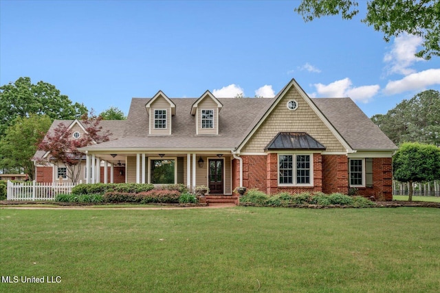 cape cod house with fence, covered porch, a shingled roof, and a front yard