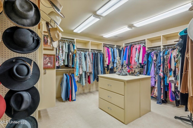 walk in closet with light carpet