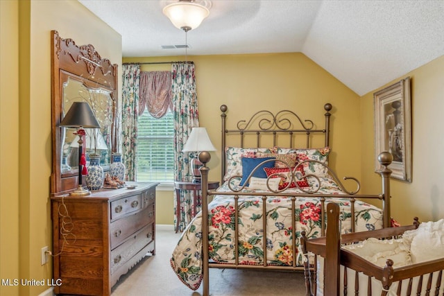 bedroom with carpet floors, vaulted ceiling, and a textured ceiling