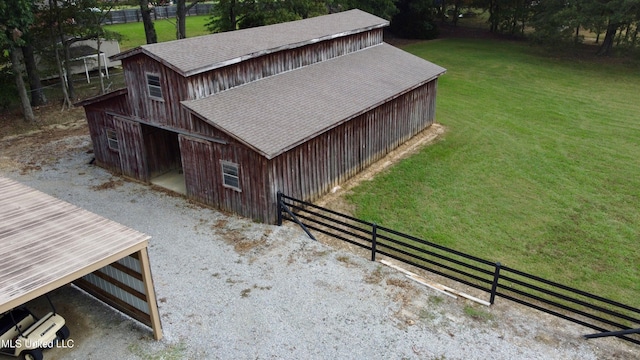 exterior space with an outdoor structure, a pole building, fence, and a yard