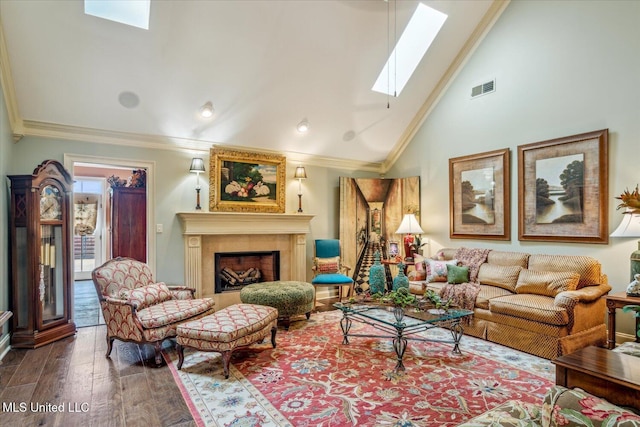 living area with visible vents, crown molding, wood finished floors, a large fireplace, and a skylight