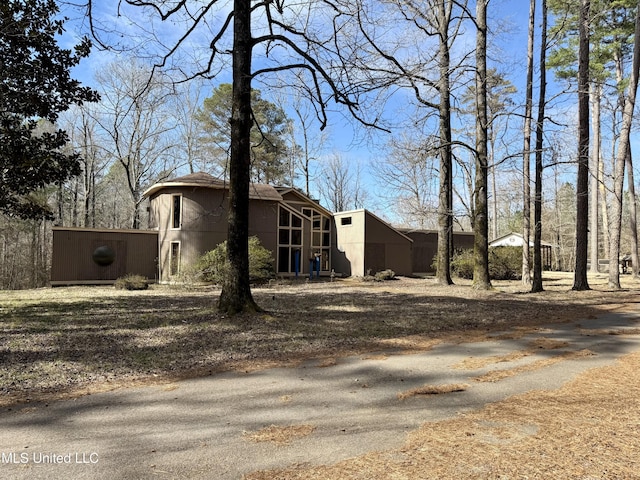 view of property exterior with a sunroom