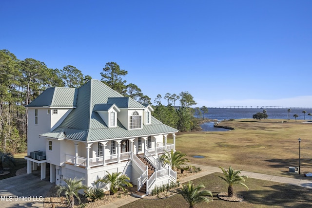 view of front of property with cooling unit, a water view, and covered porch