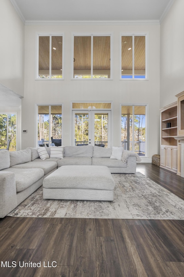 living room with french doors, crown molding, a high ceiling, and dark wood-type flooring