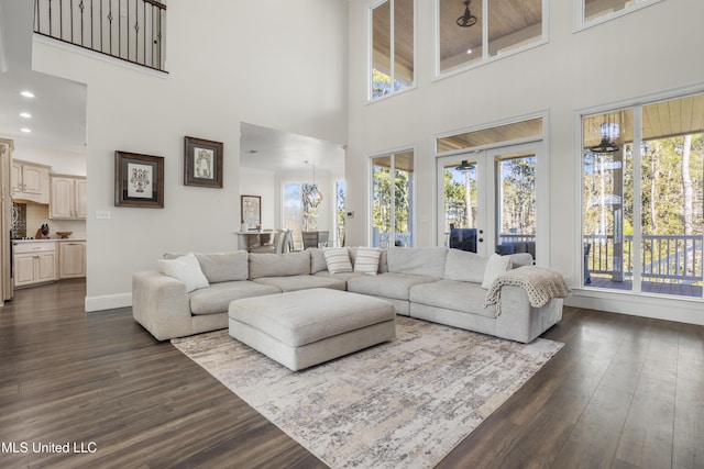 living room with a high ceiling, french doors, a wealth of natural light, and dark wood-type flooring