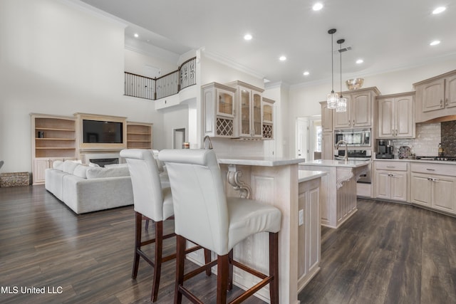 kitchen featuring pendant lighting, a kitchen bar, stainless steel appliances, and tasteful backsplash