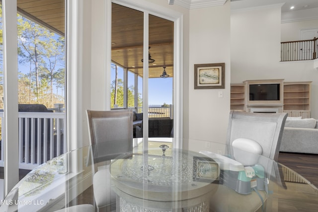 dining area featuring dark hardwood / wood-style floors, a fireplace, and crown molding