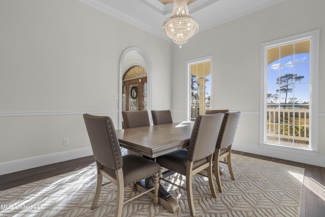 dining space featuring a chandelier, a healthy amount of sunlight, light hardwood / wood-style floors, and ornamental molding