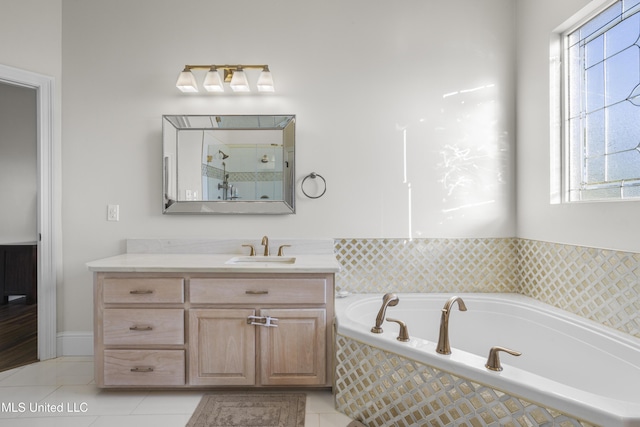 bathroom featuring plenty of natural light, vanity, a relaxing tiled tub, and tile patterned flooring