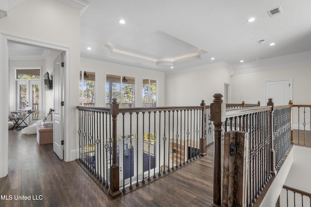 hall with dark hardwood / wood-style floors, crown molding, and a tray ceiling