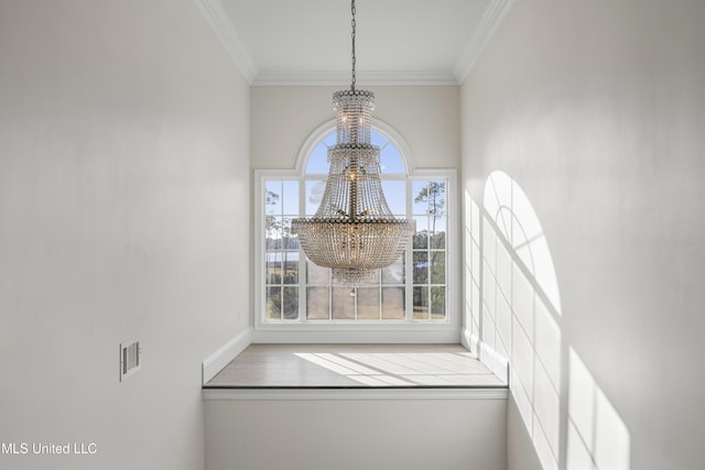 room details featuring ornamental molding and an inviting chandelier