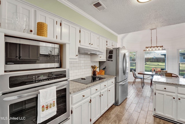 kitchen featuring decorative light fixtures, white cabinetry, a textured ceiling, and appliances with stainless steel finishes