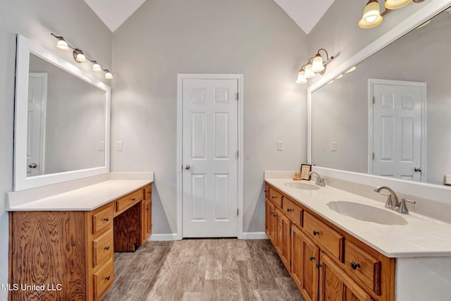 bathroom featuring vanity, wood-type flooring, and lofted ceiling