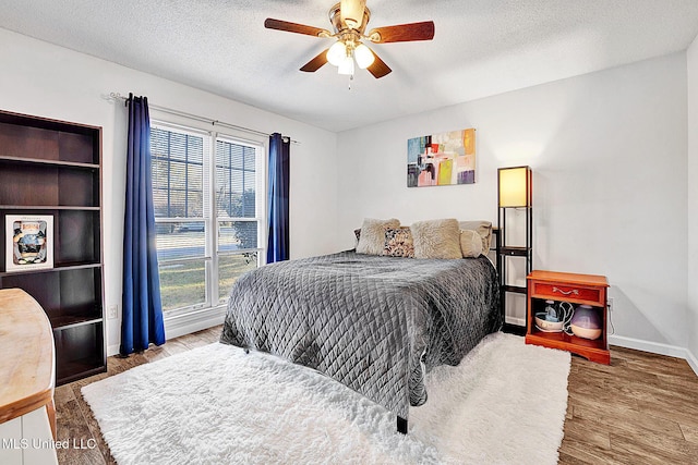 bedroom featuring hardwood / wood-style floors, ceiling fan, and a textured ceiling