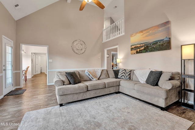 living room featuring ceiling fan, high vaulted ceiling, and wood-type flooring