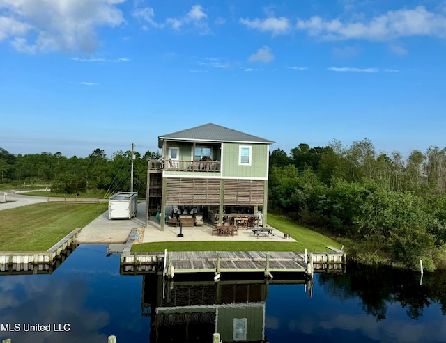 view of dock with a water view, a yard, and a patio