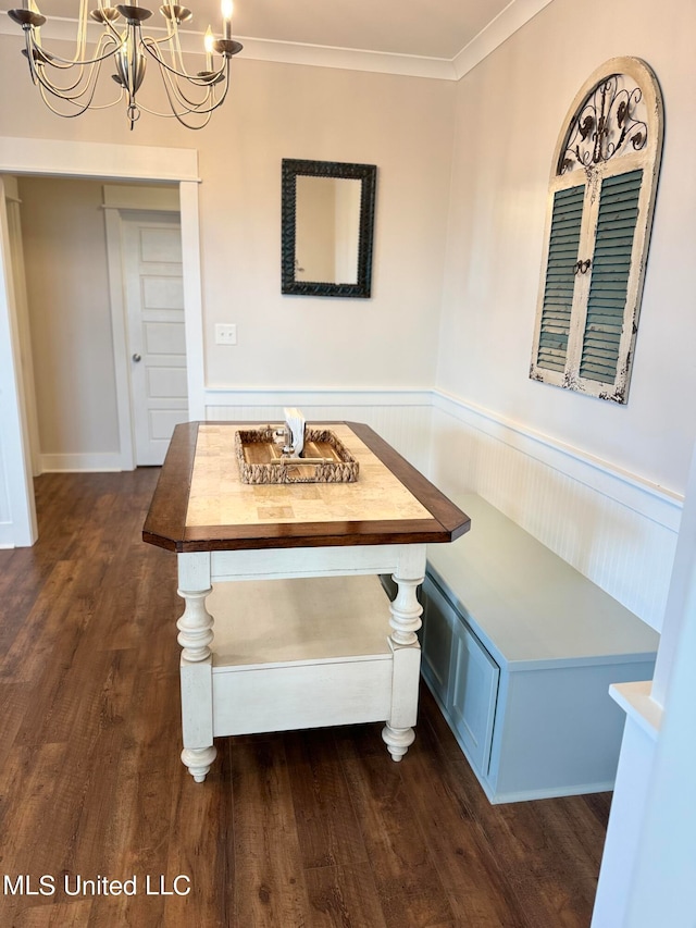 unfurnished dining area with breakfast area, an inviting chandelier, dark hardwood / wood-style floors, and ornamental molding