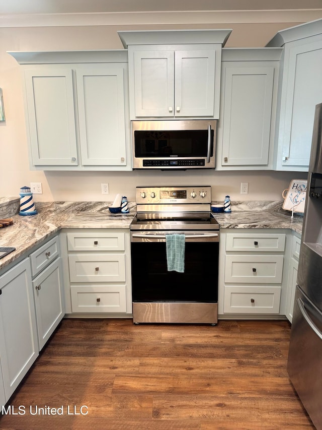 kitchen with appliances with stainless steel finishes, white cabinetry, and dark wood-type flooring