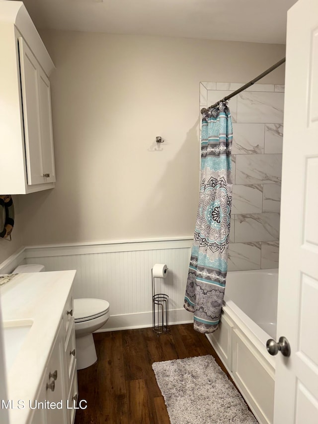 full bathroom with shower / bathtub combination with curtain, vanity, wood-type flooring, and toilet