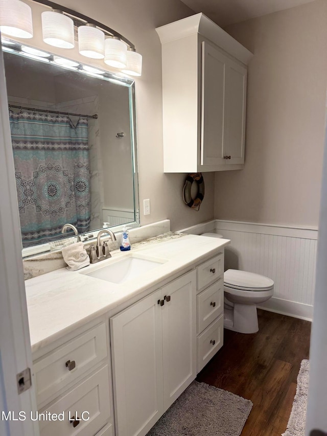 bathroom with a shower with shower curtain, vanity, wood-type flooring, and toilet