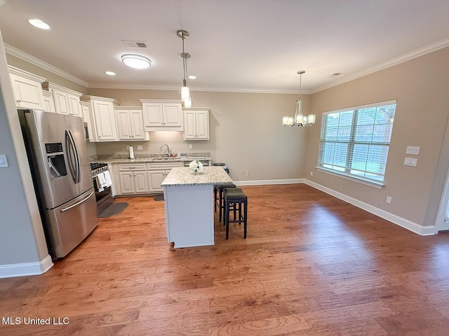 3041 Brambleberry Cv, Southaven, MS 38672 - kitchen featuring stainless steel appliances, a kitchen breakfast bar, a chandelier, light wood-style floors, and white cabinets