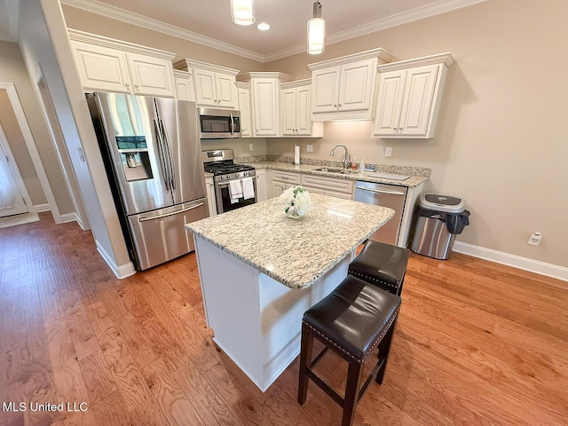 3041 Brambleberry Cv, Southaven, MS 38672 - kitchen featuring appliances with stainless steel finishes, crown molding, light stone countertops, light wood finished floors, and white cabinets