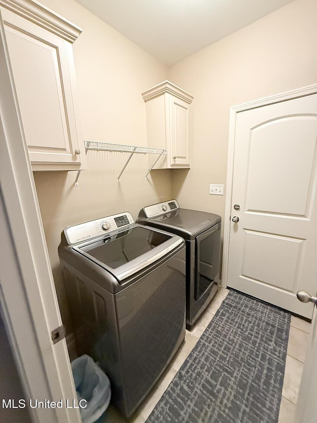 3041 Brambleberry Cv, Southaven, MS 38672 - laundry area with washing machine and dryer, cabinet space, and light tile patterned flooring