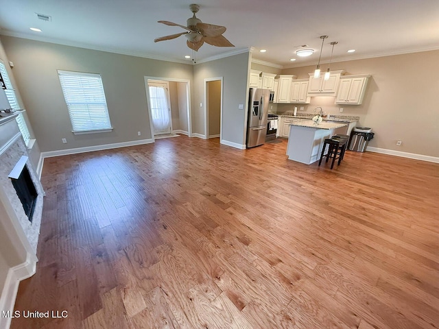 3041 Brambleberry Cv, Southaven, MS 38672 - kitchen with stainless steel appliances, a fireplace, ceiling fan, open floor plan, and a breakfast bar