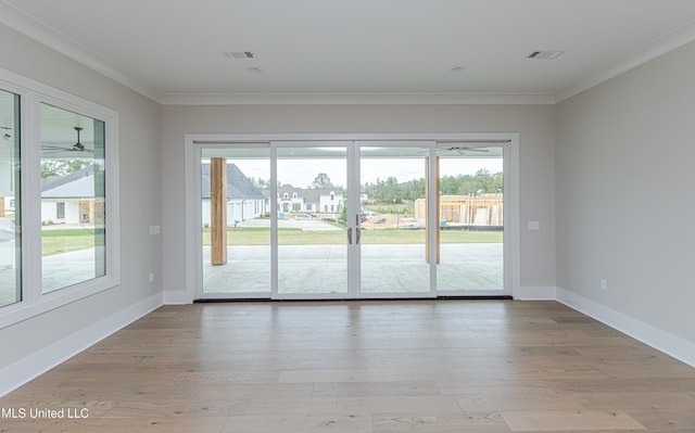 doorway to outside with plenty of natural light, light wood-type flooring, and crown molding