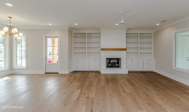 unfurnished living room featuring ornamental molding, light wood-type flooring, a healthy amount of sunlight, and a fireplace