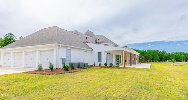 exterior space with a garage, central AC, and a yard