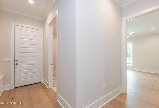 hall with light hardwood / wood-style floors and crown molding