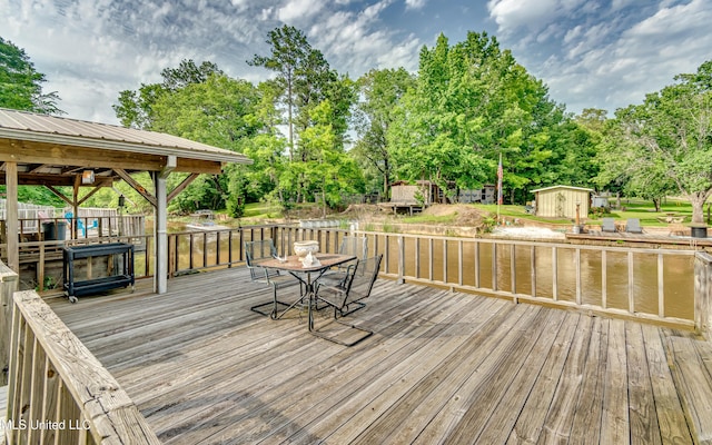 218 Harbor Ln, Brandon, MS 39047 - wooden terrace with a storage shed, view of scattered trees, an outdoor structure, and outdoor dining area