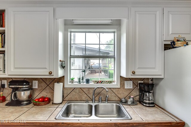 218 Harbor Ln, Brandon, MS 39047 - kitchen featuring a sink, white cabinetry, backsplash, and tile countertops