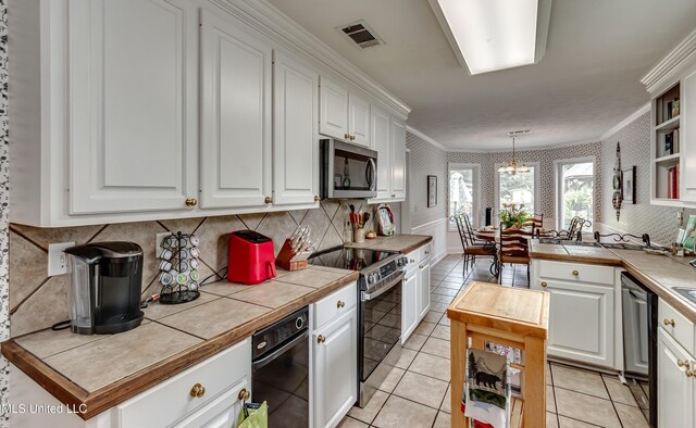 218 Harbor Ln, Brandon, MS 39047 - kitchen featuring stainless steel appliances, ornamental molding, white cabinets, a chandelier, and open shelves