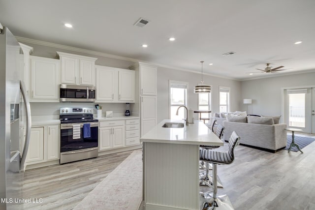 183 Mcdonnell Ave Unit 305, Biloxi, MS 39531 - kitchen featuring stainless steel appliances, ornamental molding, light wood-type flooring, open floor plan, and light countertops