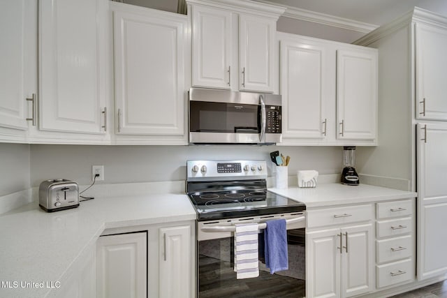 183 Mcdonnell Ave Unit 305, Biloxi, MS 39531 - kitchen with appliances with stainless steel finishes, white cabinets, light countertops, ornamental molding, and wood finished floors