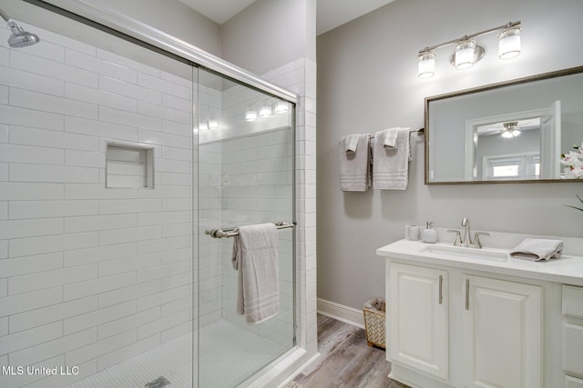183 Mcdonnell Ave Unit 305, Biloxi, MS 39531 - full bath featuring vanity, a stall shower, wood finished floors, and ceiling fan
