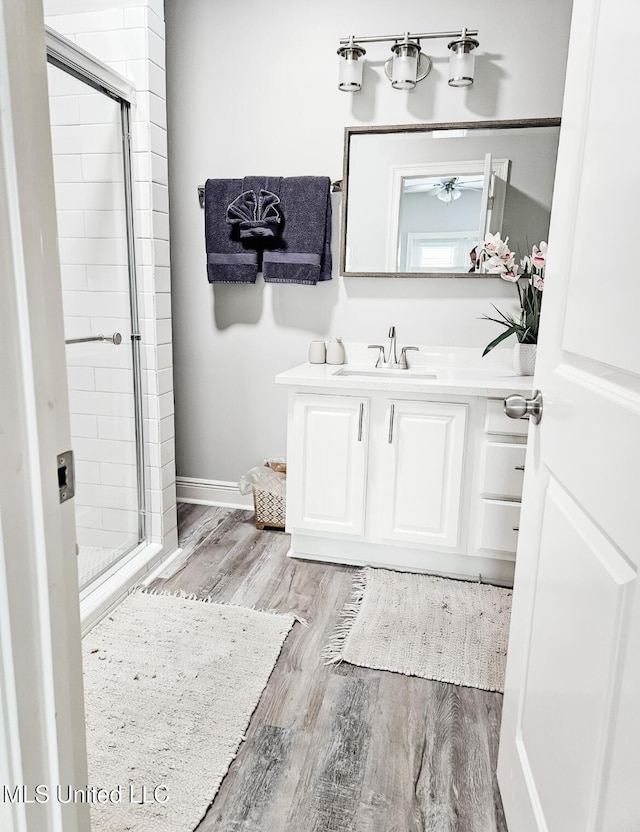 183 Mcdonnell Ave Unit 305, Biloxi, MS 39531 - bathroom with a stall shower, wood finished floors, vanity, and a ceiling fan
