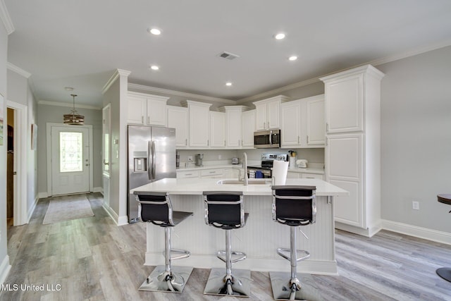 183 Mcdonnell Ave Unit 305, Biloxi, MS 39531 - kitchen featuring appliances with stainless steel finishes, white cabinets, light countertops, light wood finished floors, and crown molding