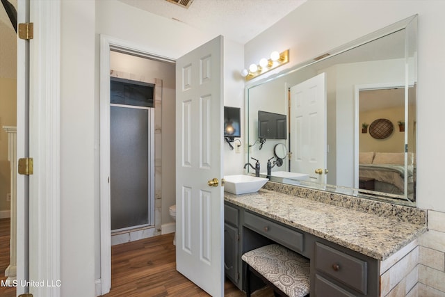 9948 Victor Dr, Olive Branch, MS 38654 - full bath featuring wood finished floors, toilet, ensuite bathroom, vanity, and a stall shower